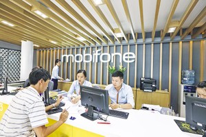 Cần có quy định rõ ràng hơn về cơ chế, chính sách để doanh nghiệp nhà nước dám đột phá, dám đổi mới. Trong ảnh: Nhân viên Mobifone hỗ trợ khách hàng tại quầy giao dịch. Ảnh: Đức Thanh