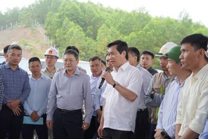 Thứ trưởng Bộ Xây dựng Nguyễn Tường Văn (cầm micro) kiểm tra tiến độ thi công Dự án thành phần Vũng Áng - Bùng tại nút giao Cự Nẫm