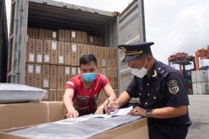 Công chức hải quan kiểm soát hàng hóa xuất nhập khẩu. (Ảnh: Bùi Nụ)