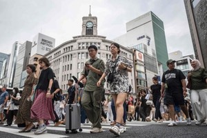 Người đi bộ băng qua đường ở khu mua sắm Ginza của thủ đô Tokyo, Nhật Bản. Ảnh: AFP