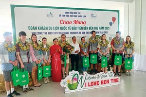 Bà Nguyễn Thị Ngọc Dung, Phó giám đốc Sở VHTTDL tỉnh Bến Tre (áo đỏ) và ngành du lịch chào mừng Đoàn khách du lịch quốc tế đầu tiên đến Bến Tre năm 2025 