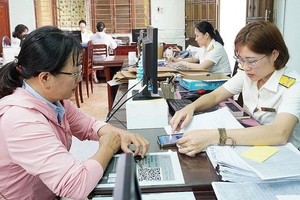Cán bộ Thuế hướng dẫn người nộp thuế thực hiện thủ tục. (Ảnh tư liệu)