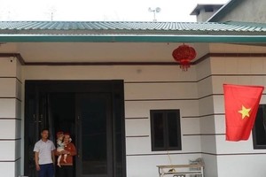 Vợ chồng anh Vàng Sành Guyện ở thôn Nậm Trà, xã Gia Phú, huyện Bảo Thắng, Lào Cai, trong căn nhà mới xây dựng. Ảnh: Hồng Ninh.