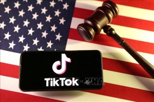 Logo của ứng dụng TikTok trên điện thoại và quốc kỳ Mỹ. Ảnh: Reuters/TTXVN