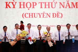 Bí thư Thành ủy TP.HCM Trần Lưu Quang tặng hoa chúc mừng 3 tân Phó chủ tịch UBND TP.HCM - Ảnh: H.K