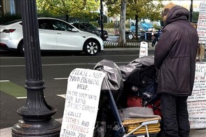 Một người vô gia cư với tấm biển cần giúp đỡ về tài chính trên một tuyến phố ở trung tâm thủ đô Washington D.C. 