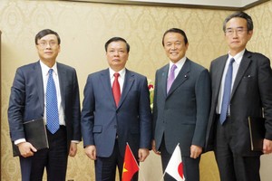 Bộ trưởng Đinh Tiến Dũng (thứ hai từ trái sang), Chủ tịch UBCK Vũ Bằng (ngoài cùng bên trái) chụp hình với Bộ trưởng Tài chính Nhật Bản Taro Aso (thứ 3 từ trái sang) trong chuyến công tác của Bộ trưởng tháng 3/2014.  