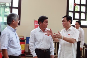 Bộ trưởng Bộ Kế hoạch và Đầu tư Bùi Quang Vinh (đứng giữa) trao đổi cùng đại biểu Quốc hội về một số vấn đề liên quan tới Dự thảo Luật 