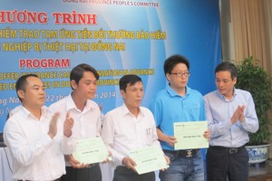 Ông Nguyễn Quang Phi - Phó Tổng Giám đốc Bảo hiểm Bảo Việt trao tiền bồi thường cho các doanh nghiệp tại Đồng Nai