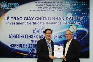 Ông Lê Hoài Quốc, Trưởng Ban quản lý Khu Công Nghệ Cao Sài Gòn trao giấy chứng nhận đầu tư cho Schneider Electric