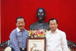 Bí thư Thành uỷ Đà Nẵng Nguyễn Xuân Anh (phải) trao quà lưu niệm cho Chủ tịch Tập đoàn Berjaya Vincent Tan.