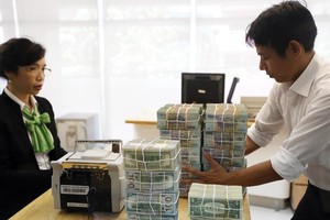 Tỷ giá USD đang chịu nhiều áp lực từ bên ngoài . Trong ảnh: giao dịch tại Ngân hàng Vietcombank. Ảnh: Đ.T