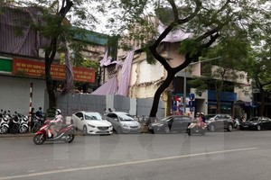 Thiếu chỗ đỗ xe, ôtô, xe máy phải đỗ trên vỉa hè. (Ảnh: Nguyễn Văn Cảnh/TTXVN)