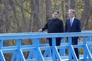 Lãnh đạo Triều Tiên Kim Jong-un (trái) đi dạo với Tổng thống Hàn Moon Jae-in tại Panmunjom ngày 27/4. Ảnh: AFP.