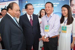 Thủ tướng Nguyễn Xuân Phúc, Nguyên Tổng bí thư Nông Đức Mạnh và các đại biểu tham quan gian hàng trưng bày của Masan tại Hội nghị