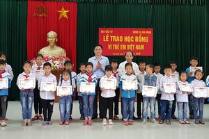 Ông Lã Quý Hưng, Trưởng Đại diện Báo Đầu tư tại khu vực (hàng thứ 2 - bên phải) và ông Đặng Thanh Sơn, Phó giám đốc Sở Kế hoạch và Đầu tư tỉnh Ninh Bình (hàng thứ 2 - bên trái) trao học bổng cho hoc sinh Trường Tiểu học, THCS xã Gia Hưng.