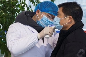 Nhân viên y tế kiểm tra sức khỏe  ở sân bay Trường Sa, tỉnh Hồ Nam, hôm 27/1. Ảnh: Reuters.