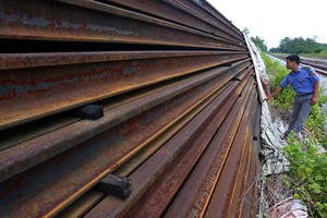 Hơn 20 nghìn thanh ray và cả tấn bu lông, ốc vit với trị giá trên 300 tỷ đồng vẫn đang được phủ bạt sau gần 10 năm mua sắm. (Ảnh: Bá Đô - Vnexpress).