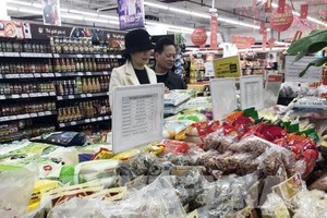 Khách lựa chọn hàng hóa tại siêu thị Vinmart. Ảnh: Trần Việt - TTXVN 