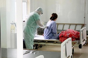 Bác sĩ khám bệnh cho người được cách ly tại Bệnh viện dã chiến số 2. Ảnh: Nguyễn Thiêm.