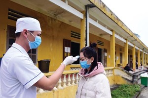 Kiểm tra thân nhiệt người dân trong khu cách ly tập trung tại tỉnh Lào Cai. Ảnh: Giang Huy