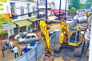 Trong không ít trường hợp, việc xây dựng công trình, nâng nền đường ở TP.HCM đã khiến nhiều tuyến phố trở thành điểm chứa nước mỗi khi trời mưa hay triều cường. Ảnh: Lê Toàn