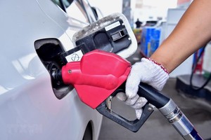 Nhân viên bơm xăng cho phương tiện tại một trạm xăng ở Hà Bắc, Trung Quốc. (Ảnh: THX/TTXVN)