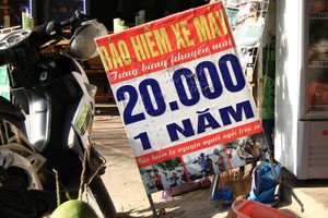 Những biển quảng cáo bán bảo hiểm xe máy với giá 20.000 đồng/năm xuất hiện nhan nhản trên các tuyến phố ở Hà Nội