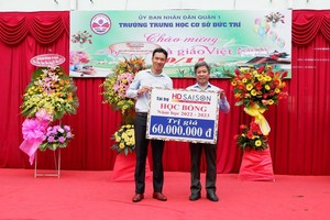 Đại diện HD SAISON trao học bổng cho Đại diện Ban giám hiệu nhà trường.