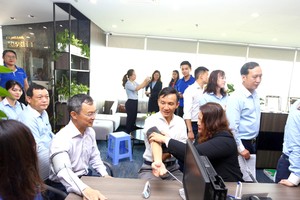 Ông Đào Hồng Châu – Phó tổng giám đốc của Eximbank (bên trái) đang kiểm tra sức khỏe trước khi tham gia hiến máu cùng CBNV của ngân hàng.