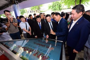 Phó Thủ tướng Hồ Đức Phớc trải nghiệm các tính năng thanh toán mới tại Ngày hội không tiền mặt diễn ra sáng 14/6 ở TP.HCM. 