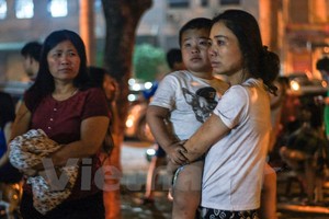 Nhiều em nhỏ ngơ ngác khi đang ngủ ngon nhưng lúc tỉnh dậy lại thấy đang ở ngoài đường trong cảnh hỗn loạn. (Ảnh: PV/Vietnam+)