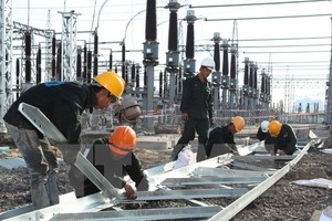 Công nhân Công ty Cổ phần Lắp máy (INCO) lắp đặt thiết bị xuất tuyến tại trạm biếp áp nhà máy nhiệt điện Cẩm Phả. (Ảnh: Ngọc Hà/TTXVN)