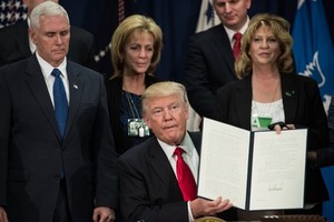 Tổng thống Donald Trump ký sắc lệnh bắt đầu kế hoạch xây tường biên giới với Mexico tại Bộ An ninh Nội địa ngày 25/1. Ảnh: AFP.