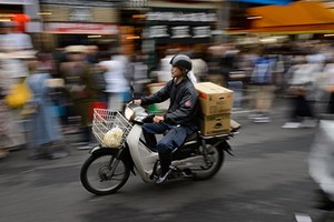 Một chiếc xe máy 50cc chở hàng tại chợ cá Tsukiji. Ảnh: Bloomberg