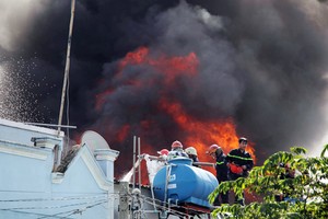 Lửa táp vào khu dân cư, cảnh sát đang phong tỏa đám cháy. Ảnh: Sơn Hòa.