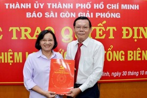 Đồng chí Thân Thị Thư, Ủy viên Ban Thường vụ Thành ủy, Trưởng Ban Tuyên giáo Thành ủy TPHCM trao quyết định bổ nhiệm lại chức danh Tổng Biên tập Báo SGGP đối với đồng chí Nguyễn Tấn Phong.