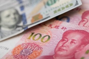 Đồng 100 USD của Mỹ và 100 NDT của Trung Quốc. Ảnh: AFP.