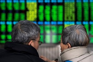 Trái với nhiều thị trường khác, chứng khoán Trung Quốc biểu thị màu xanh là giảm điểm, màu đỏ là tăng điểm. Ảnh: AFP