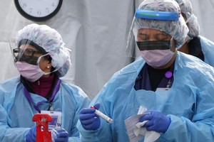 Y tá mặc đồ bảo hộ tại khu xét nghiệm Covid-19 ở trung tâm y tế Đại học Washington, Seattle. Ảnh: AFP.