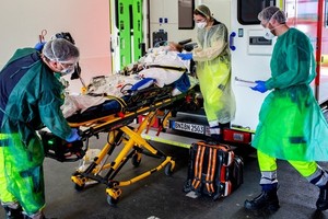 Nhân viên y tế chuyển bệnh nhân Covid-19 từ Italy tới bệnh viện ở phía tây nước Đức hôm 28/3. Ảnh: AFP.