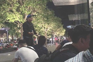 Nhân viên Apple Store (đội mũ xanh) cố khuyên nhóm xếp hàng không nên tụ tập quá sớm.