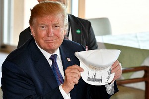 Tổng thống Mỹ Trump cầm chiếc mũ có chữ "Khiến liên minh ngày càng vĩ đại hơn" ở Nhật ngày 5/11. Ảnh: AA.