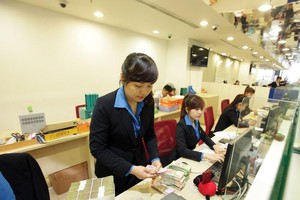 Các ngân hàng mong muốn được nới room cho khối ngoại để nâng cao năng lực vốn. Trong ảnh: Giao dịch tại Ngân hàng SCB.