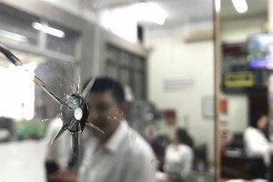 Viên đạn nghi phạm bắn còn găm trên cây cột của ngân hàng.