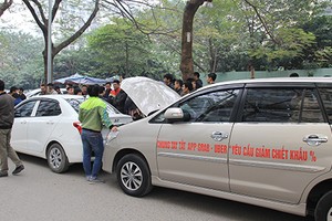 Tài xế dán khẩu hiệu với thông điệp yêu cầu Uber, Grab giảm chiết khấu lên thân xe. Ảnh: Anh Tú