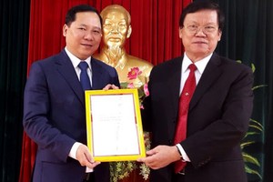 Ông Nguyễn Phi Long, Bí thư TƯ Đoàn (trái), nhận quyết định phân công nhiệm vụ mới . Ảnh: T.Thế