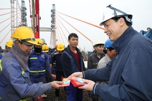 Chủ tịch UBND tỉnh Quảng Ninh trò chuyện, chúc Tết công nhân thi công dự án cầu Bạch Đằng ngày 30 Tết. Ảnh: Đỗ Phương