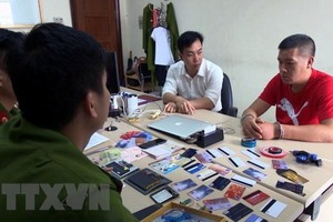 Lực lượng chức năng lấy lời khai đối tượng Vương Đại Sâm. (Ảnh: Nguyễn Hoàng/TTXVN)