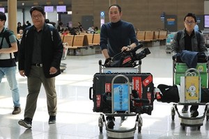 Phóng viên Hàn Quốc tại sân bay quốc tế Incheon ở Seoul trước khi lên đường sang Bắc Kinh, Trung Quốc hôm nay. Ảnh: Yonhap.